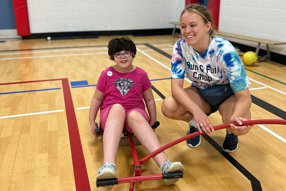 child and volunteer in gymnasium