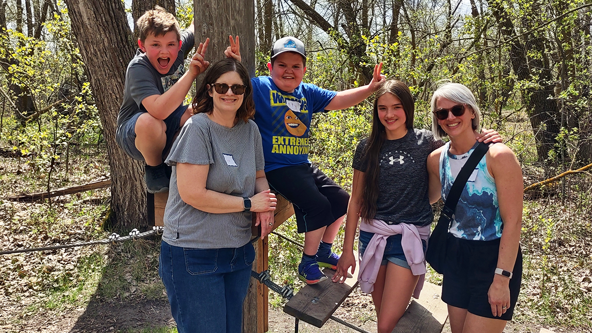 Liz Bannister (grey shirt) and Max Bannister (blue shirt) pose with another family at the RCC SSCY Family Network Retreat.