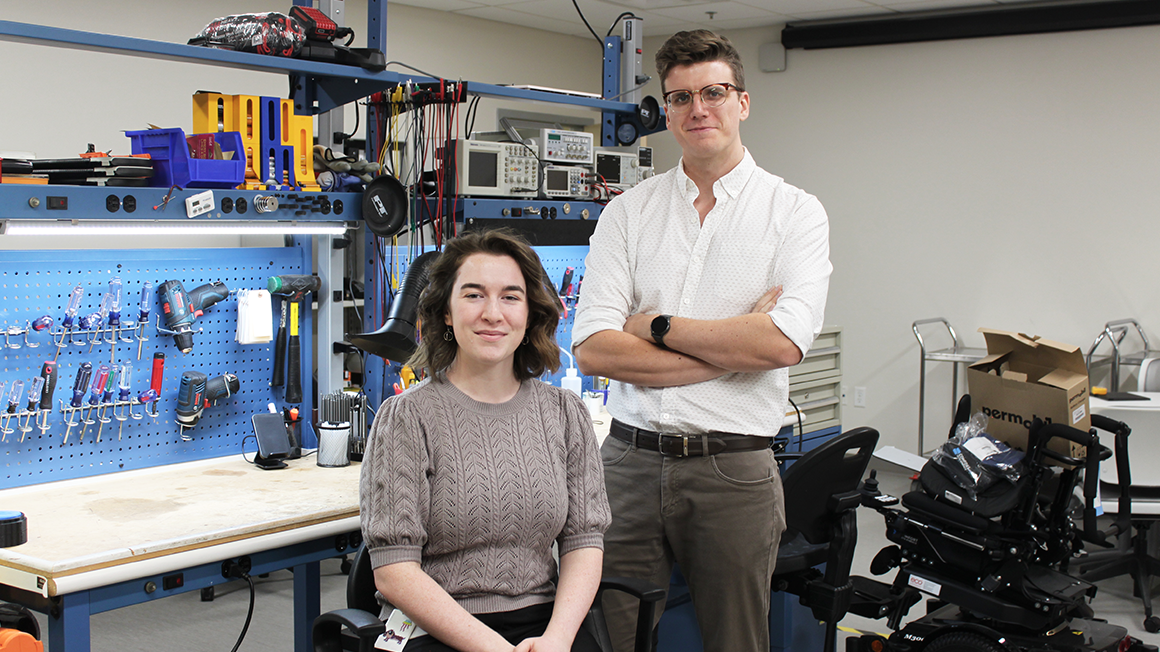 Subjects pose for a photo in front of tool work space. Rowen Guncheon sits in chair. Shea Hunt poses beside her.