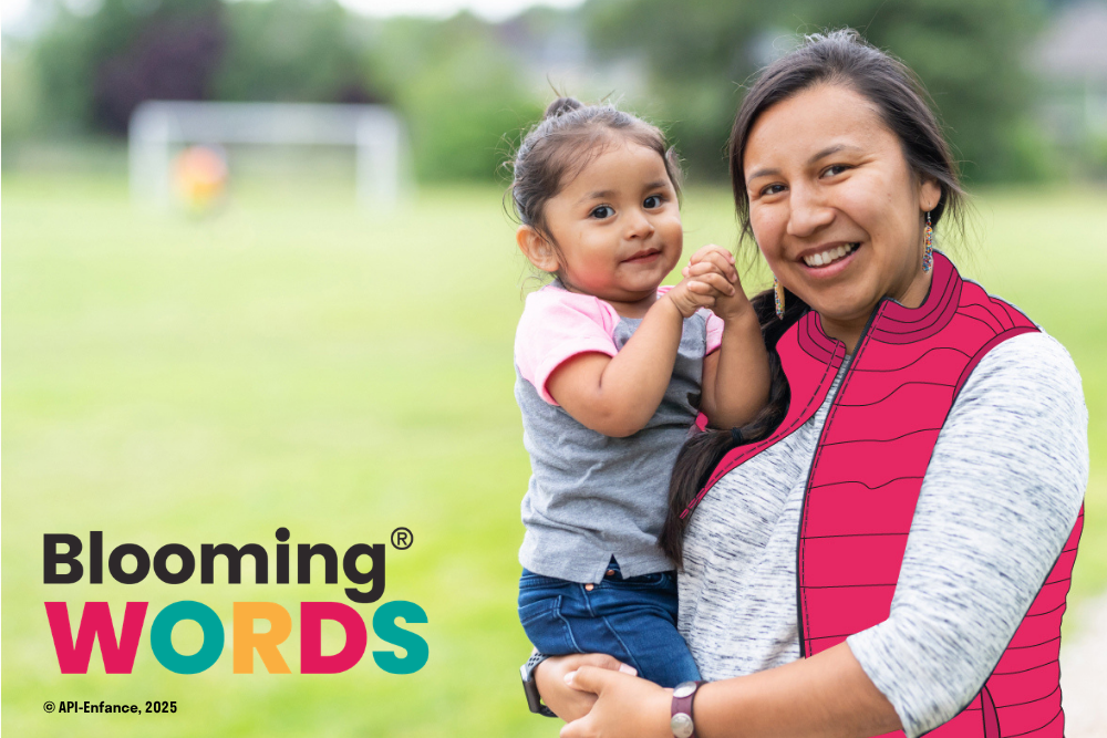Smiling woman holds child. Blooming Words written in bottom left corner.